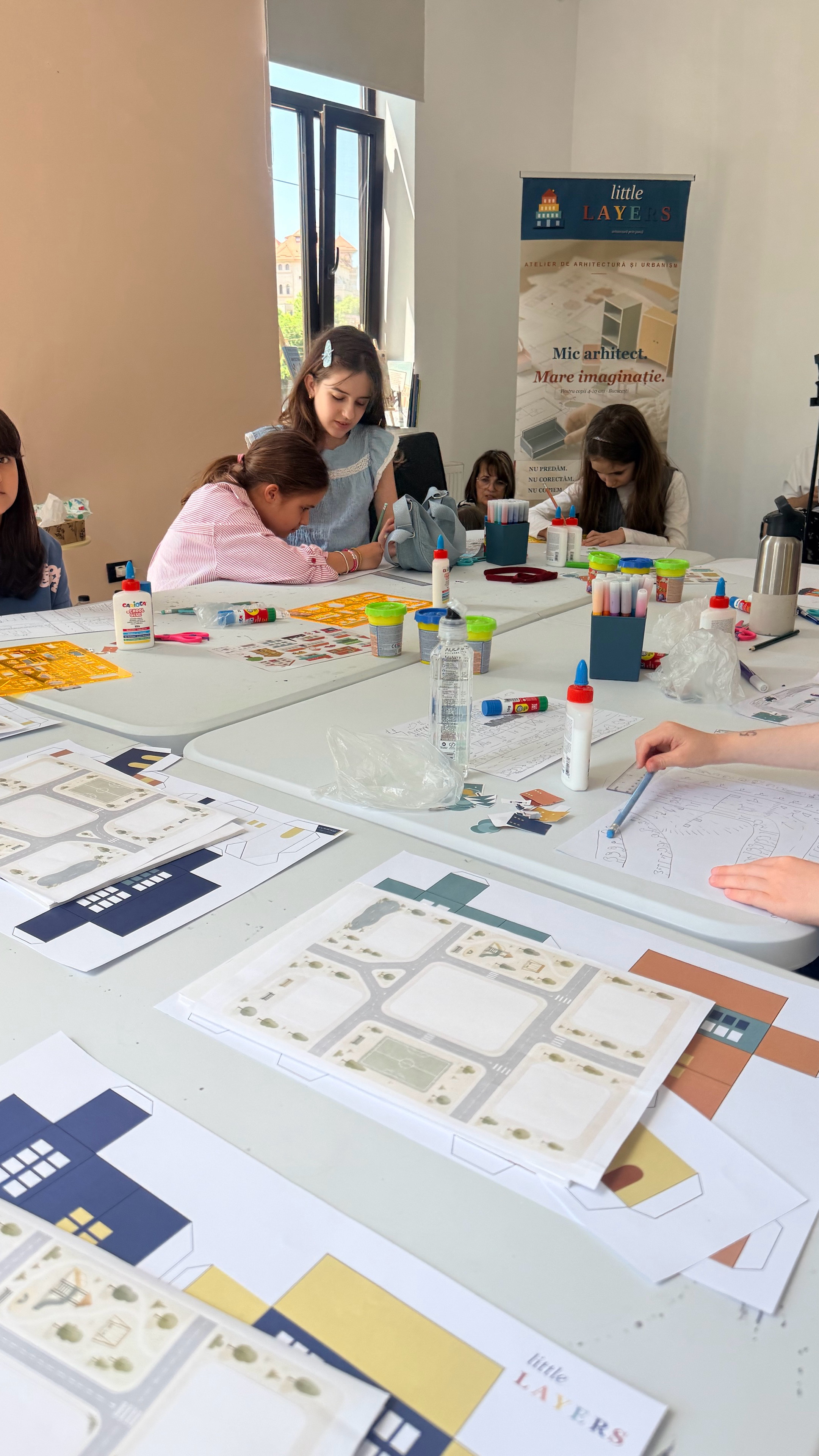 Trei băieți construind clădiri într-o sală de grupă