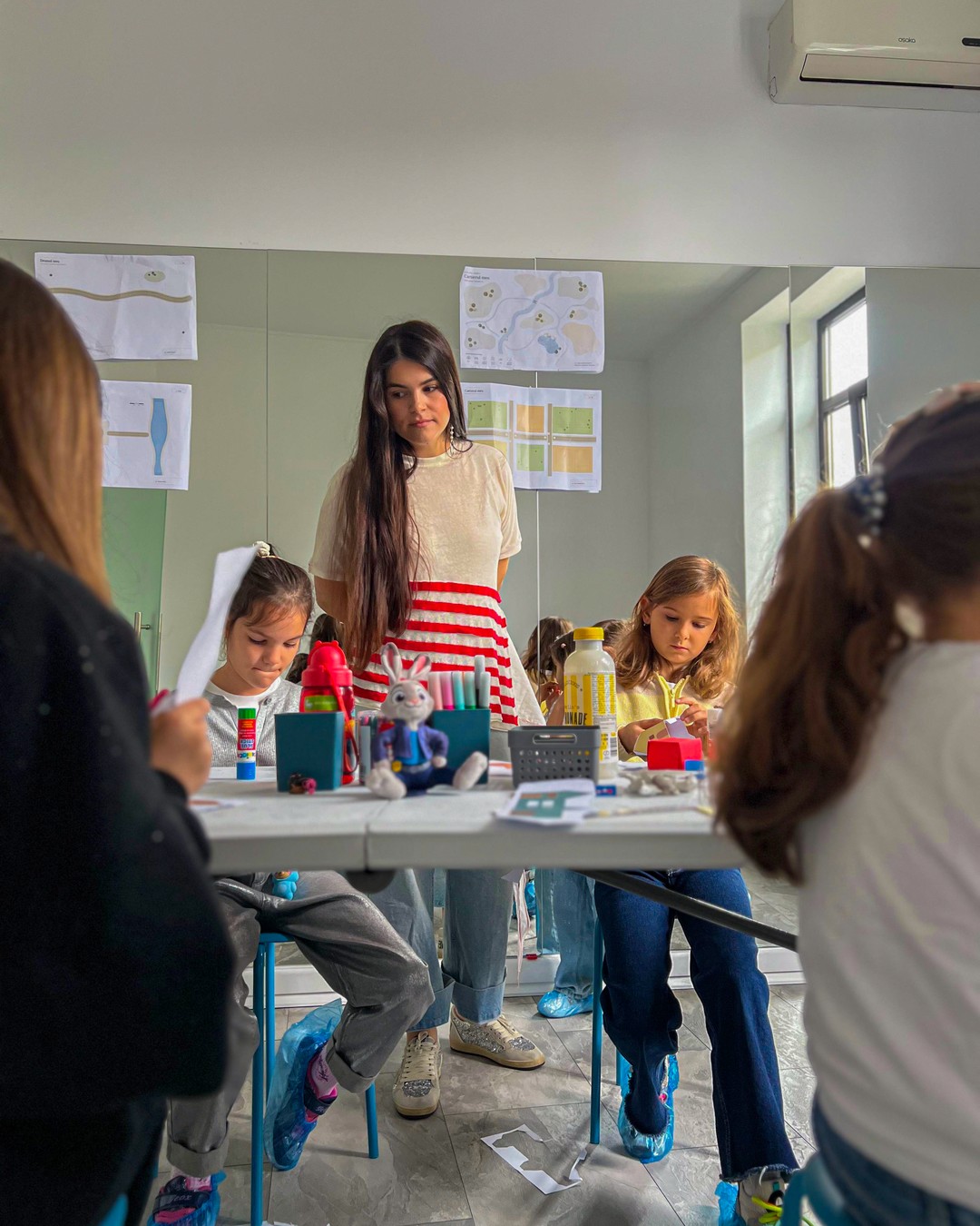 Ioana explică un material unui copil în studio
