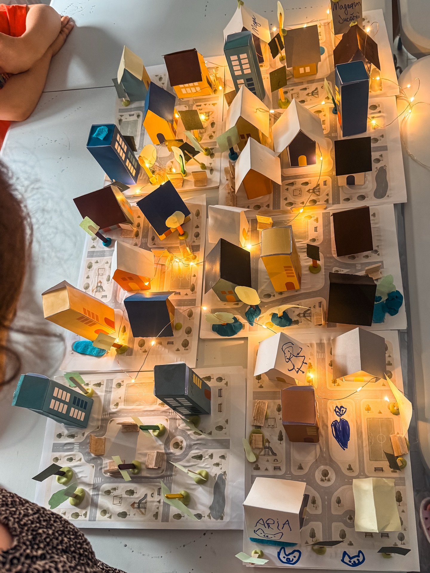 Cartierul construit de copii, văzut de sus, cu căsuțele luminate de lămpi mici