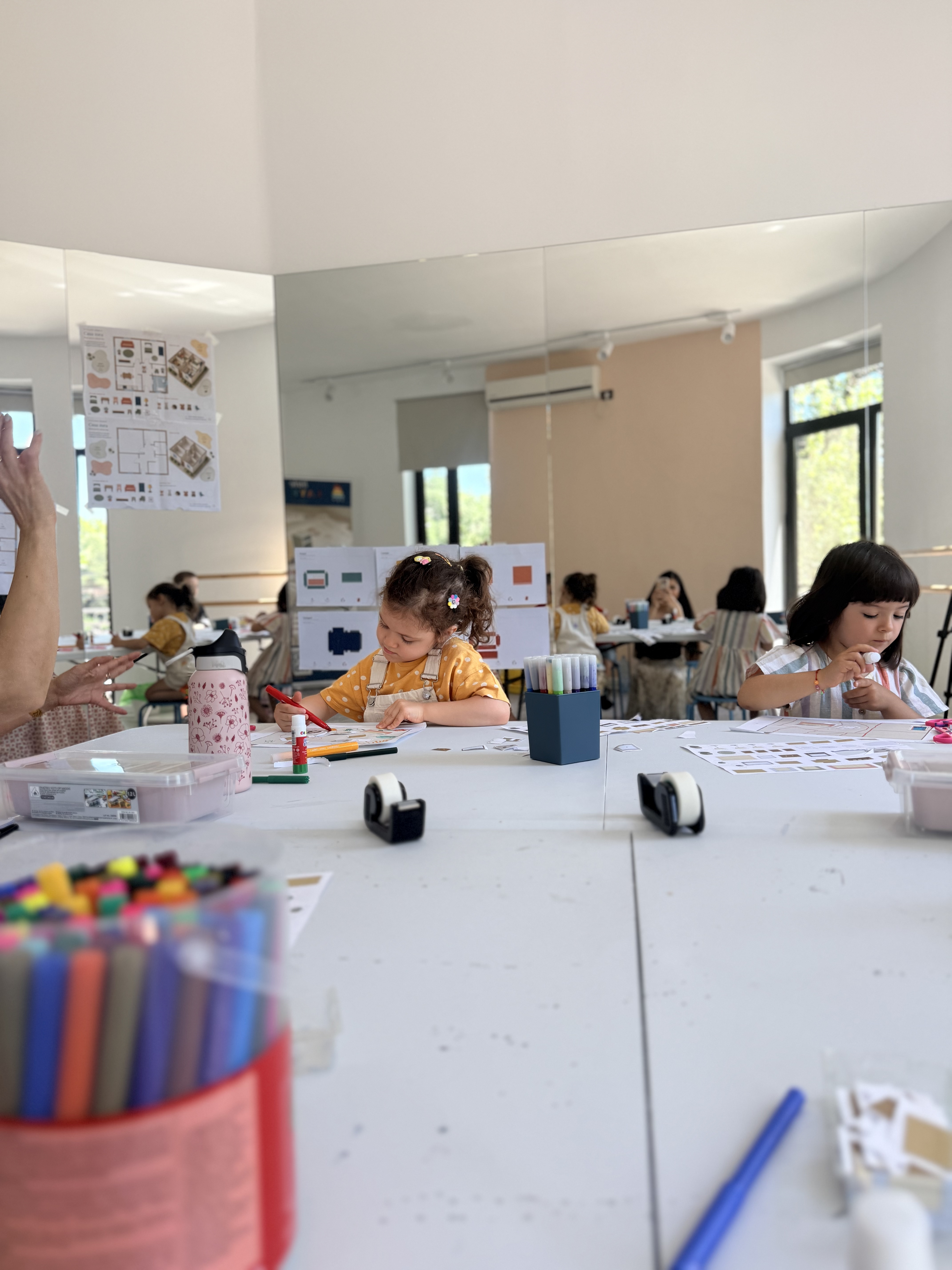 Atelier restrâns, lumină caldă, un copil lucrând atent la macheta lui